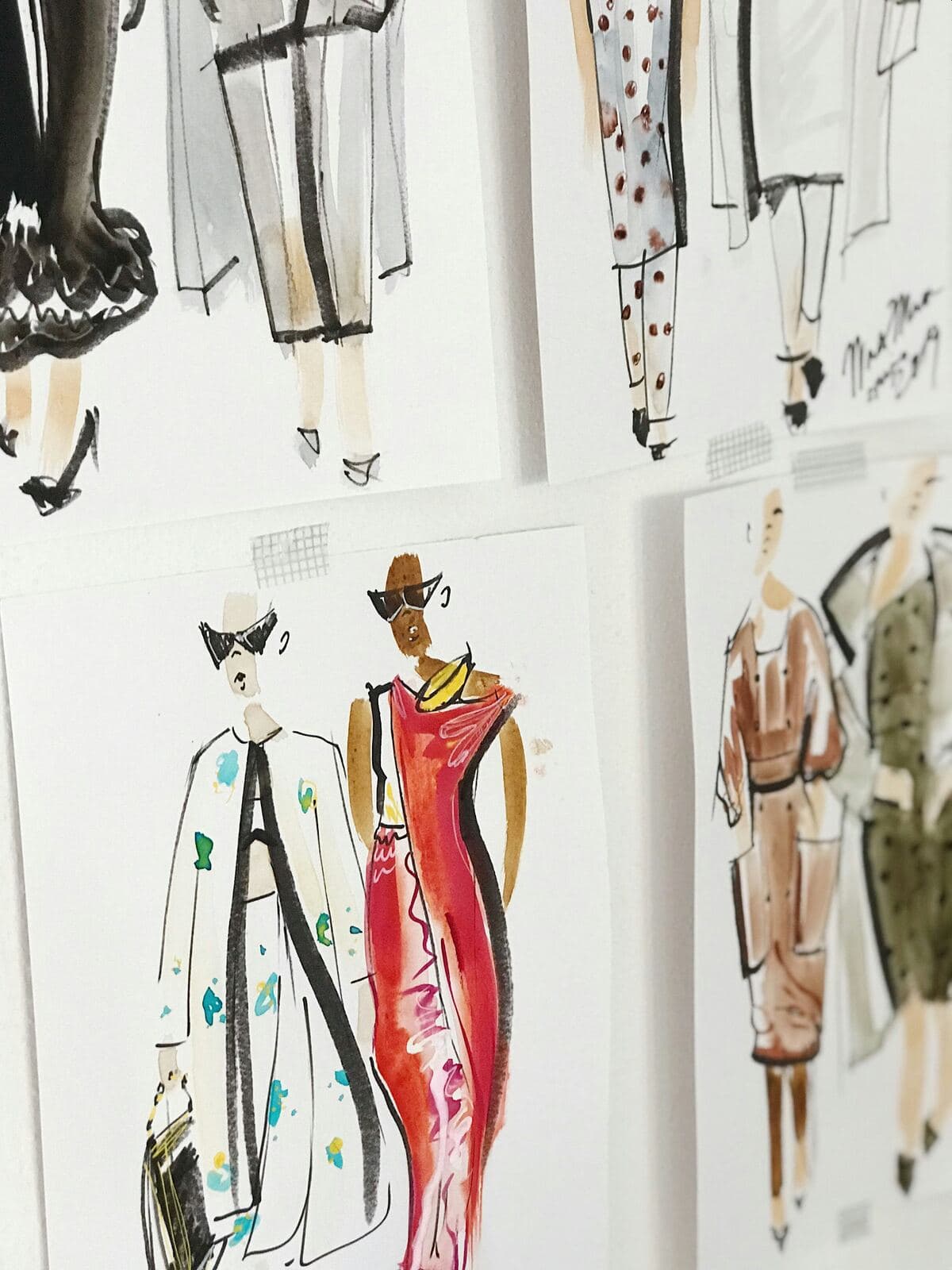 Watercolour fashion sketches pinned to a wall