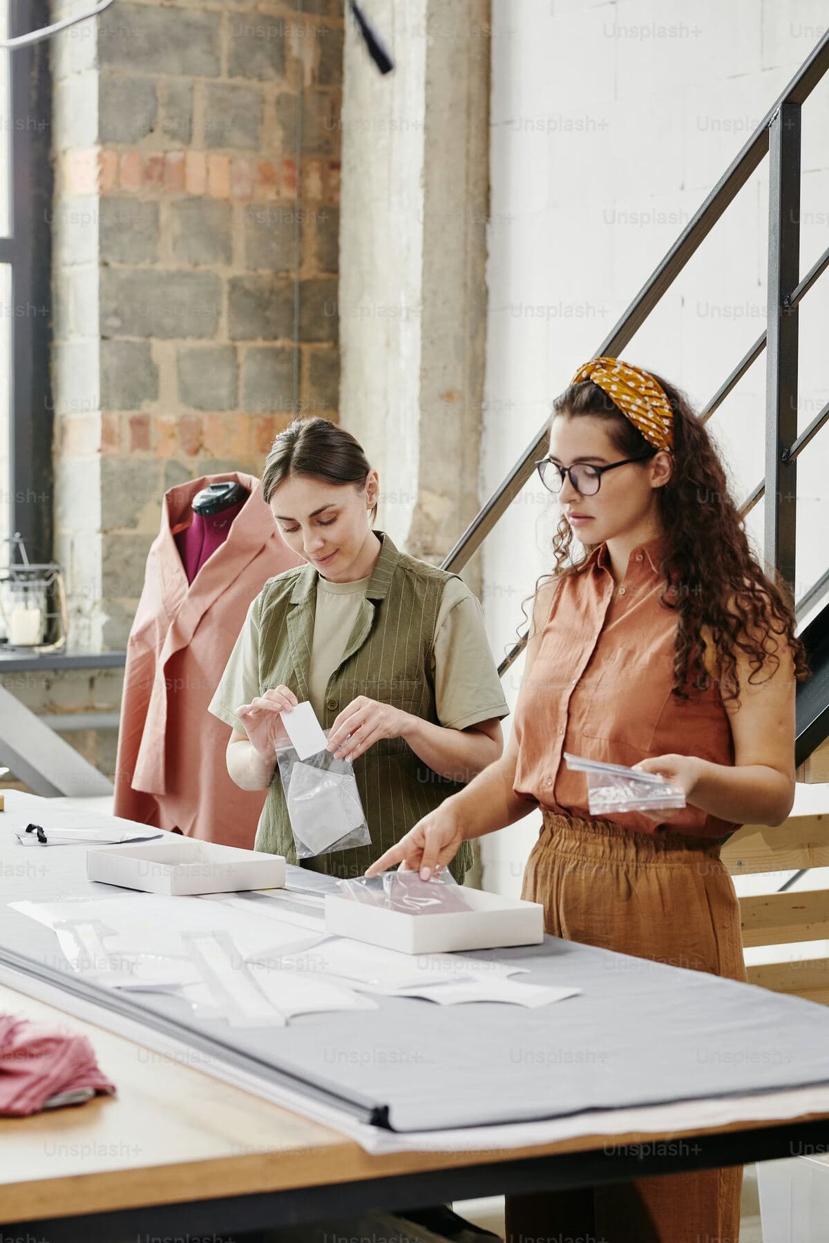 Two designers comparing fabric samples at a worktable