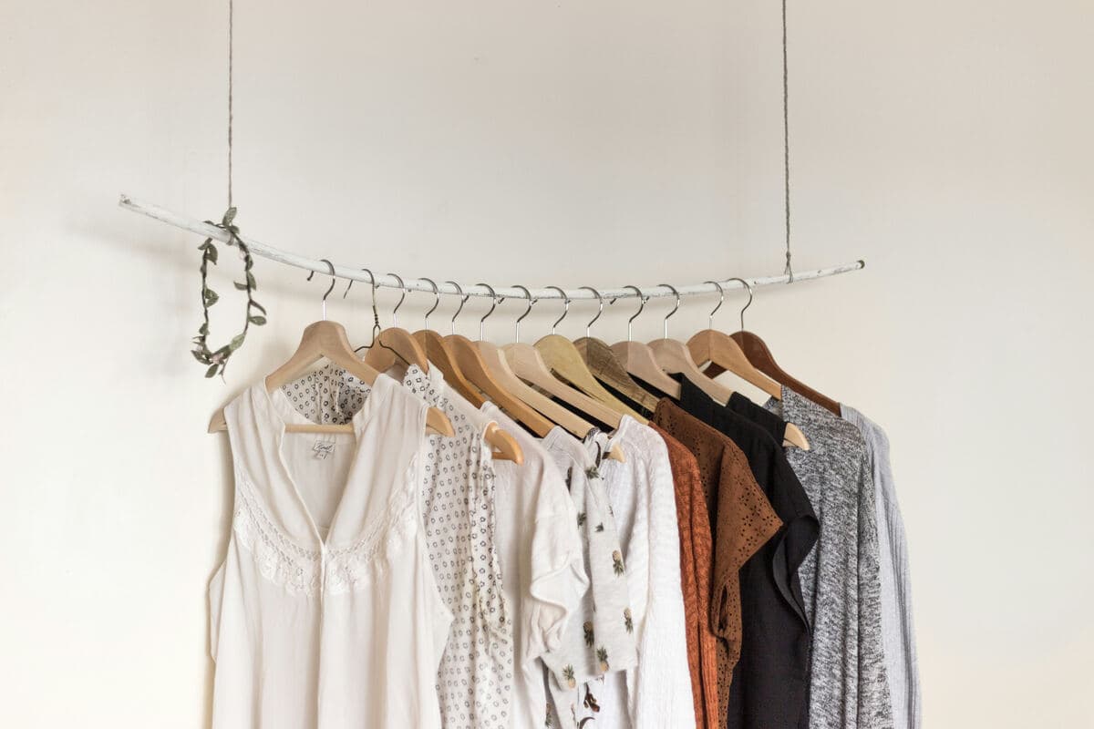 Finished garments hanging on a rail, from white to brown to grey